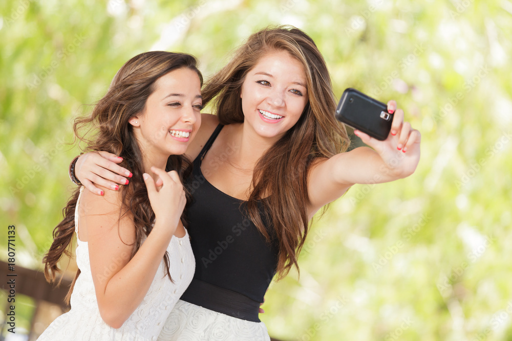 Two Attractive Mixed Race Girlfriends Using Their Smart Cell Phones For Selfie Outdoors Two Attractive Mixed Race Girlfriends Using Their Smart Cell Phones For Selfie Outdoors