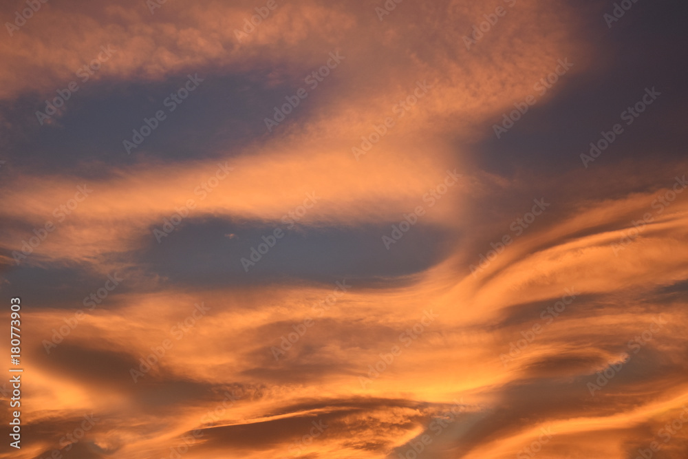 Strange and unusual cloud with spiral pink, orange, golden and blue at sunset in the sky of Turin, Italy.