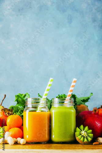 Freshly blended fruit smoothies of various colors and tastes in glass jars in rustic wooden tray. Yellow, green.