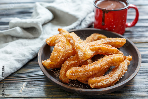 Dish with churros and hot chocolate.