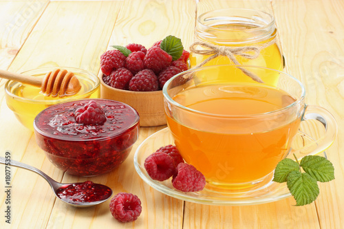 healthy background. raspberry with raspberry jam, honey and tea on light wooden background