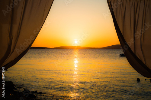 idyllischer ruhiger Sonnenuntergang am Strand mit Vorhang
