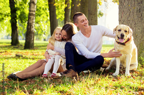 Happy family with their dog in the park on a sunny day