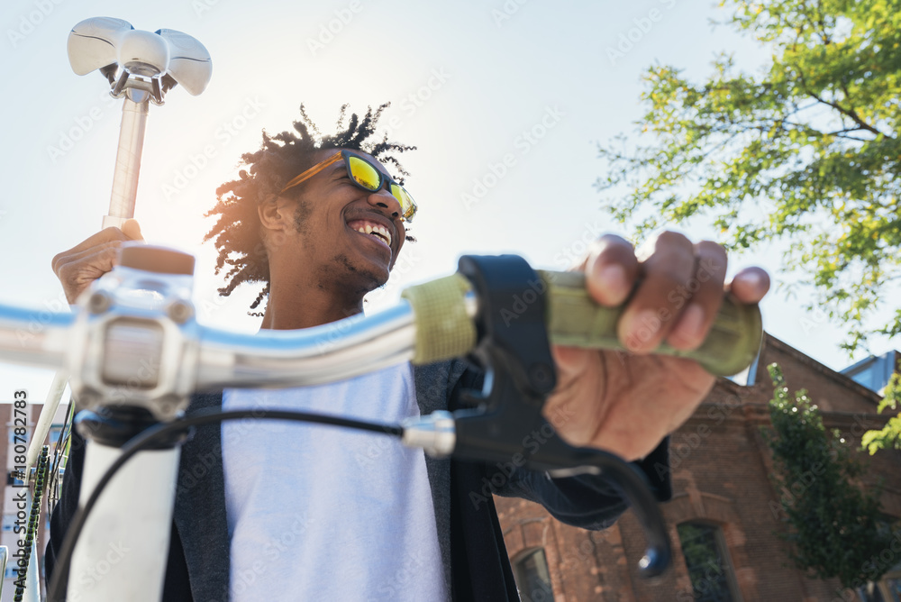 © santypan - Handsome afro man riding a bike.
