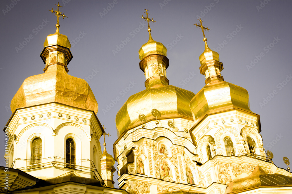 Famous Saint Michael Golden Domed Monastery left photo. Yellow cupola of baroque church on blue sky background. Cupola toning. Vintage