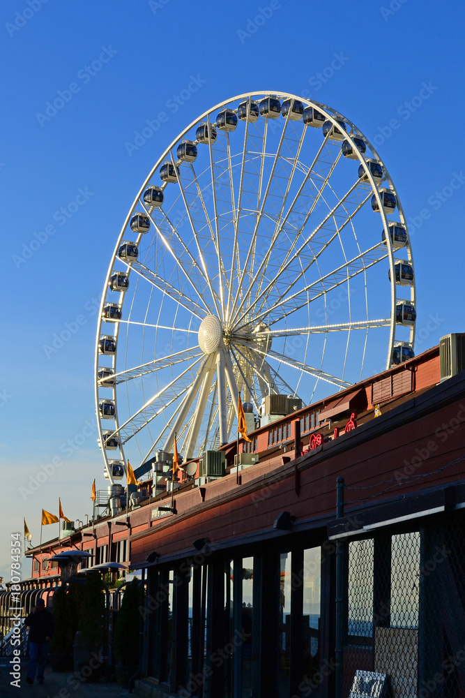 A ferris wheel in Seattle, Washington seen from a little wooden pier  at the city waterfront