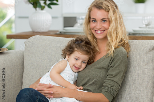 happy little girl doing big hug to mother