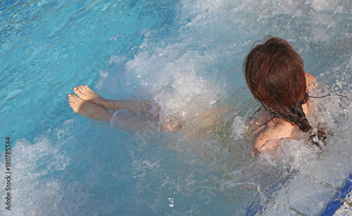 woman during hydromassage sitting in the pool in a luxurious spa