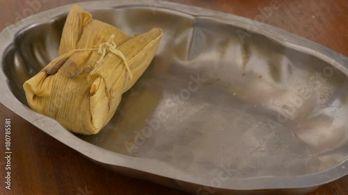 Sideshot shot of a tray been filled with tamales for serving