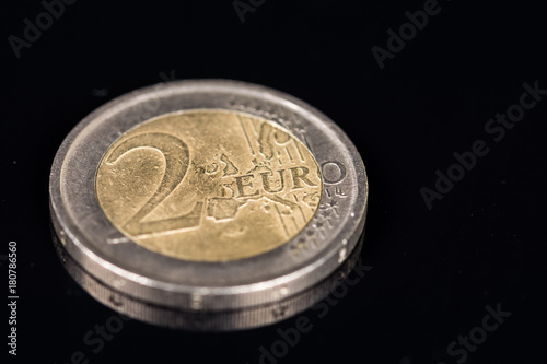 Metal coin of two euros on the black background with reflections