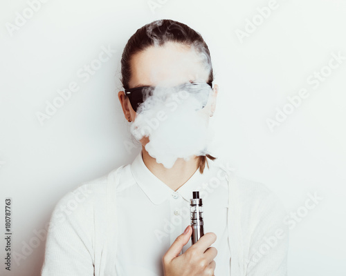 Bild auf Leinwand Woman in sunglasses smokes an e-cigarette