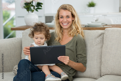 mother and daughter watching tv on tablet