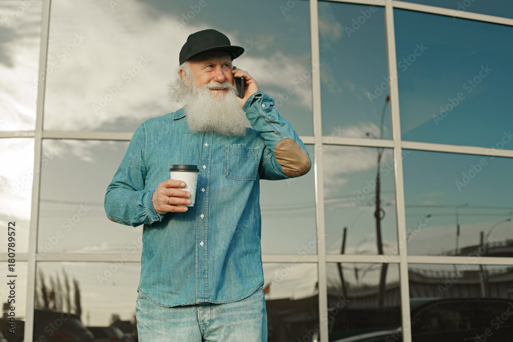 old man with a beard and coffee talking on the phone old man with a beard and coffee talking on the phone