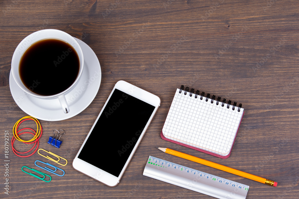 Top view of Cup of coffee with smart phone on wooden background. Technology, successful business and advertising concept Top view of Cup of coffee with smart phone on wooden background. Technology, successful business and advertising concept