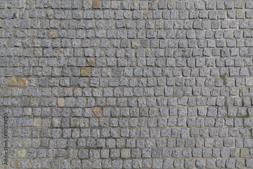 The road is paved with granite stones of a square shape as a background or a backdrop