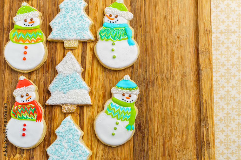 Christmas snowman and tree cookies on the cutting board winter selebration background.