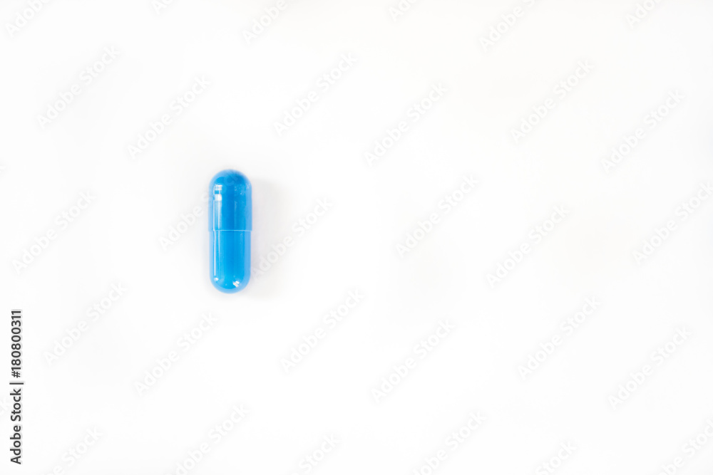Single straight blue capsule or pill on white background Single straight blue capsule or pill on white background