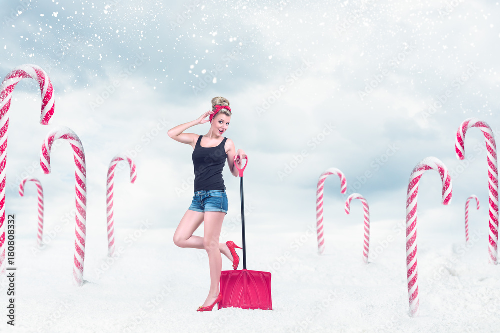 Obraz na plátně Pin-up girl with snow shovel