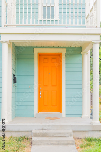 Bright colored front door of remodeled urban home  tangerine orange and light turquoise baby blue