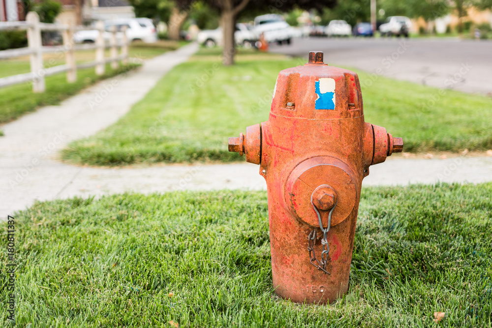 Dirty old fire hydrant on grassy street corner of urban community Dirty old fire hydrant on grassy street corner of urban community