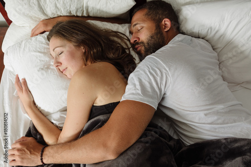 Black and white couple sleeping in bed