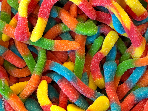 Sour candy gummy worms close up background. Covered in granulated sugar