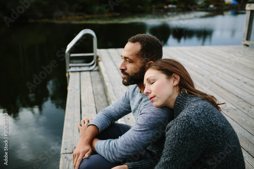 Black and white couple cuddling at the lake