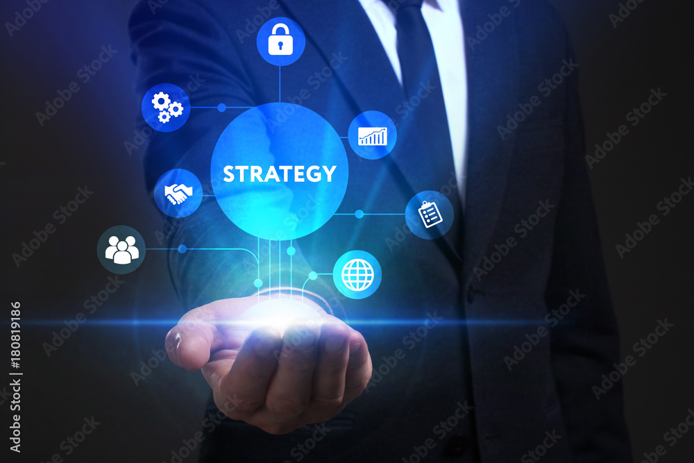 Obraz premium Business, Technology, Internet and network concept. Young businessman working on a virtual screen of the future and sees the inscription: Strategy