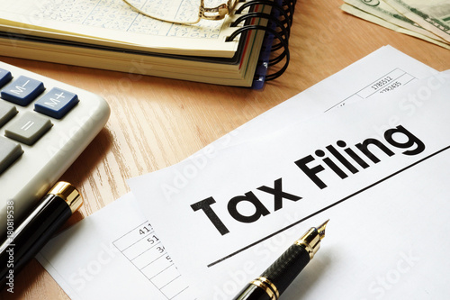 Papers with title Tax filing on an office desk.