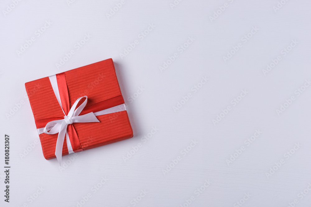 Red gift box on white wooden background