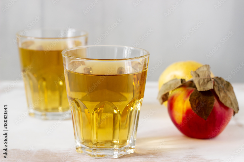 Apple juice in glasses and fresh apples on a wooden background. Rustic style. Apple juice in glasses and fresh apples on a wooden background. Rustic style.