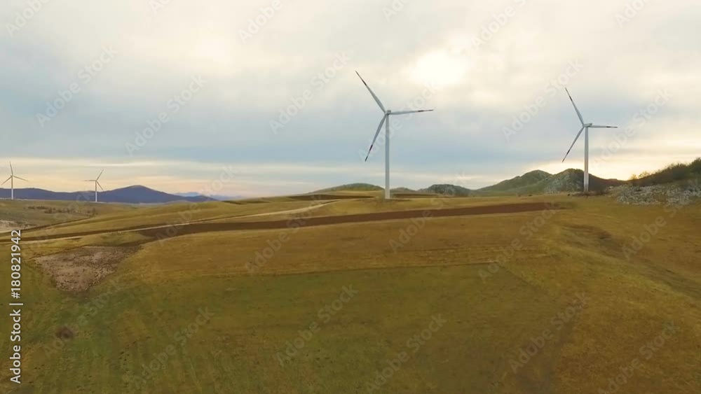 Aerial View of Wind Turbine Fields with cloudy sky in the background Aerial View of Wind Turbine Fields with cloudy sky in the background