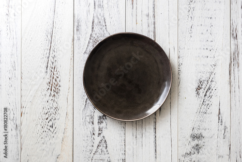 Black Plate on white wooden background