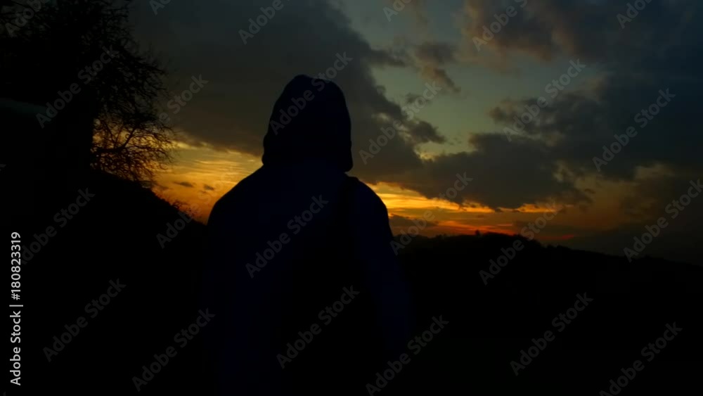Unknown woman silhouette observing sunset clouds on the sky. Unknown woman silhouette observing sunset clouds on the sky.
