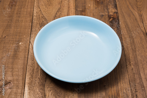 Blue Plate on brown wooden background side view