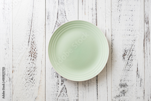 Green Plate on white wooden background