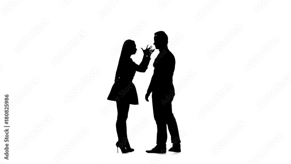 Guy and girl are arguing, they have a scandal. Silhouette. White background. Slow motion Guy and girl are arguing, they have a scandal. Silhouette. White background. Slow motion