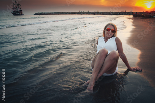 Blond woman on the beach near sea in the evening