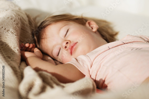 Sleeping little girl. Carefree sleep little baby with a soft toy on the bed.