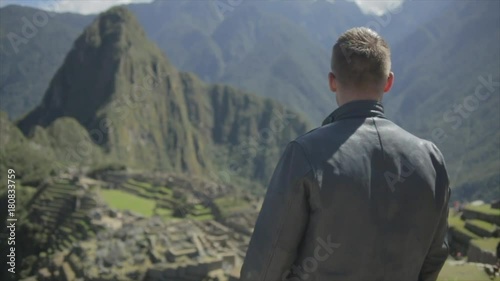 Man steps into frame and enjoys the view at Machu Picchu.