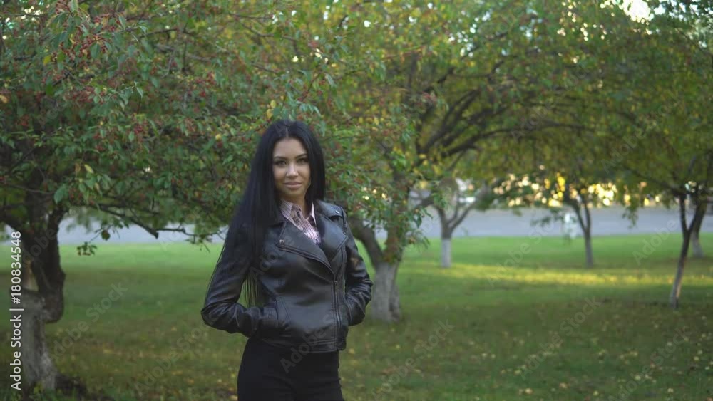 young pretty woman in shirt and black jacket posing in autumn park young pretty woman in shirt and black jacket posing in autumn park
