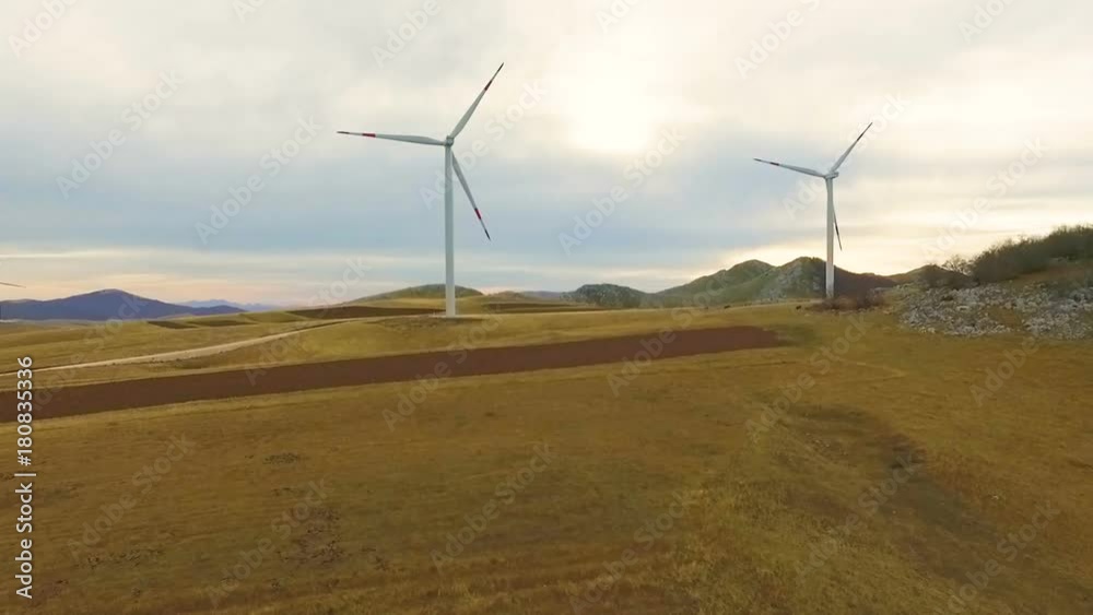 Aerial View of Wind Turbine Fields with cloudy sky in the background Aerial View of Wind Turbine Fields with cloudy sky in the background