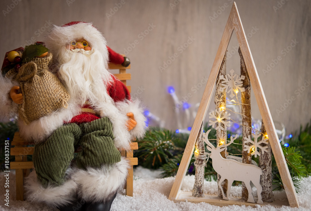 Obraz premium Christmas ornaments with snow, pine tree, Santa Claus and xmas lights