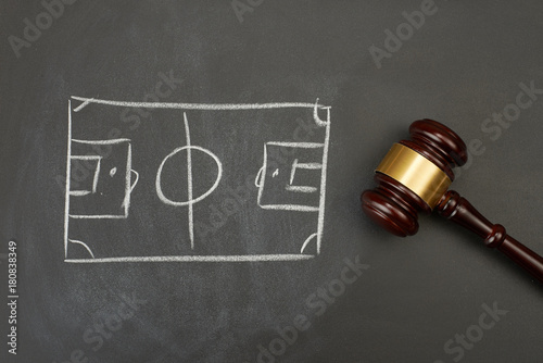 Judge gavel on blackboard background with painted soccer court.
