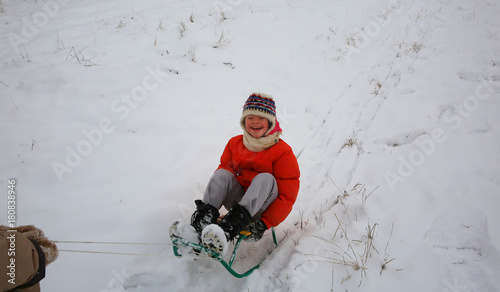 Little girl have fun in the winter with sleigh
