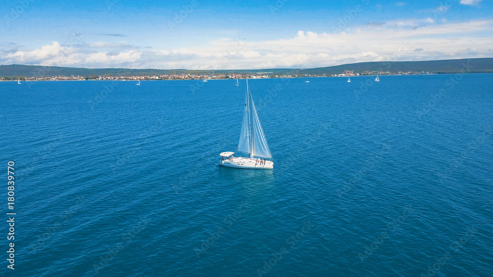 Obraz premium Aerial view of yacht sailing near beautiful Islands. Beautiful clouds in the background. Luxury yacht in the sea.