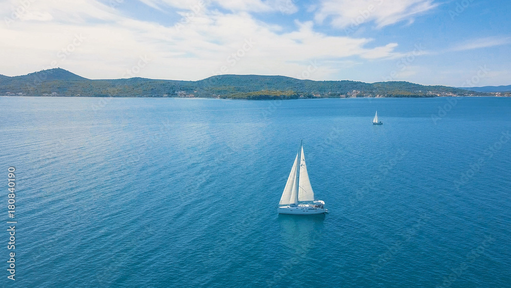 Obraz premium Aerial view of yacht sailing near beautiful Islands. Beautiful clouds in the background. Luxury yacht in the sea.