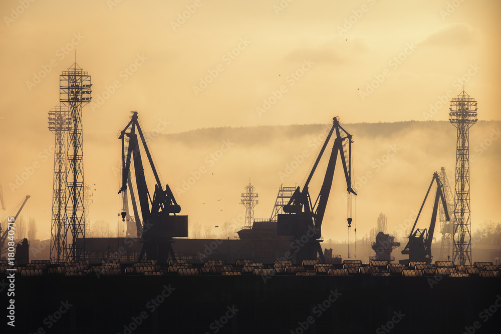 Panoramic view toward sea port and industrial cranes