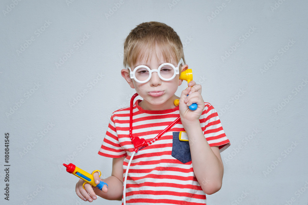 Boy playing doctor. Toy syringe and glasses. Portrait Boy playing doctor. Toy syringe and glasses. Portrait
