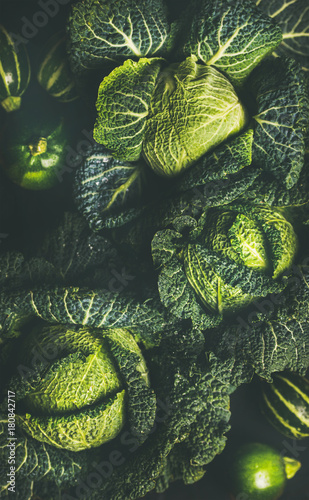 Raw fresh green cabbage texture and background, over dark background, top view, selective focus, vertical composition